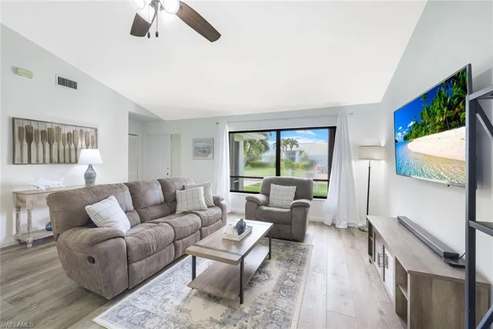 Living room featuring light hardwood / wood-style floors, ceiling fan, and high vaulted ceiling