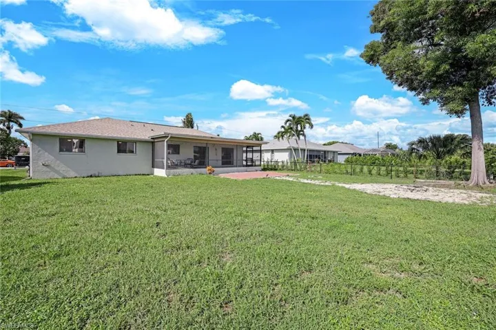 Back of house with a sunroom and a lawn
