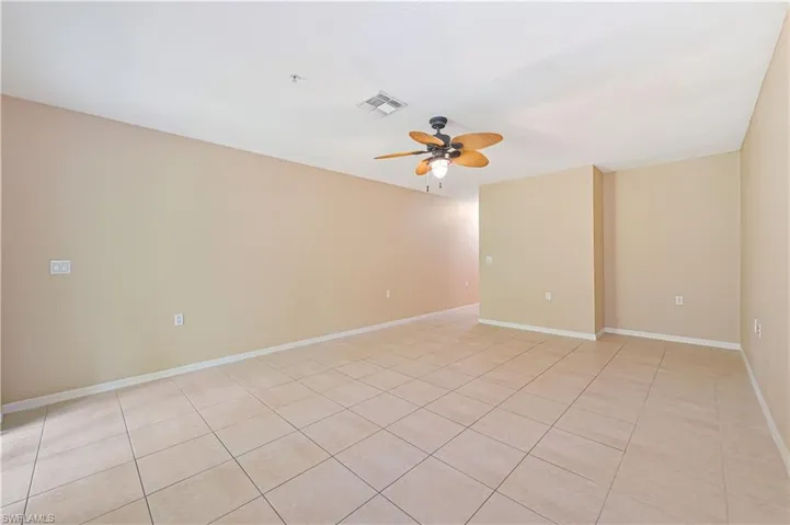 Spare room with ceiling fan and light tile floors