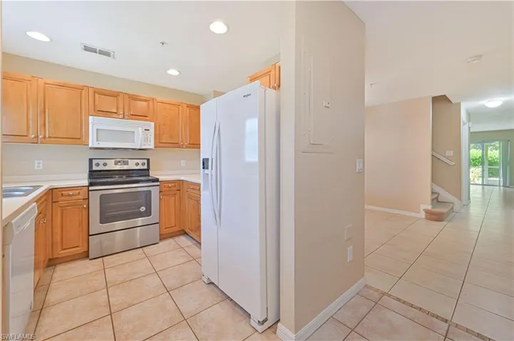 Kitchen with white appliances and light tile floors