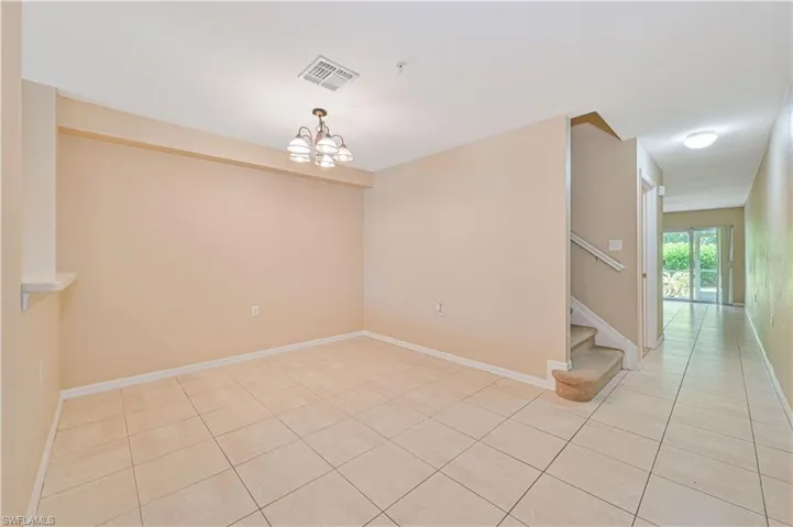 Unfurnished room with a notable chandelier and light tile flooring