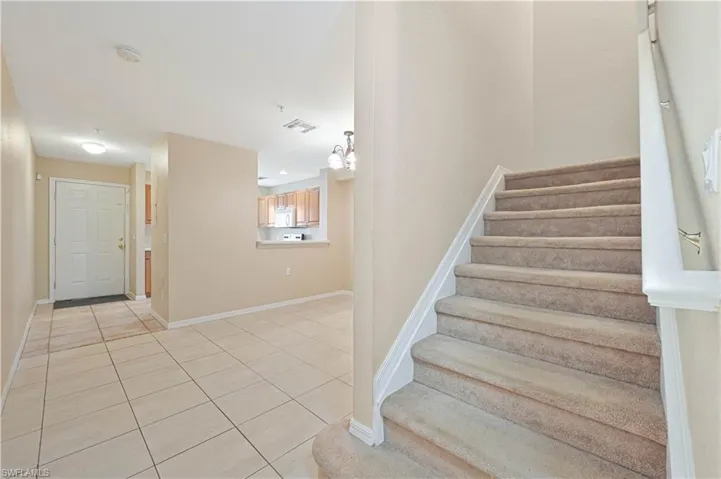 Staircase featuring light tile floors