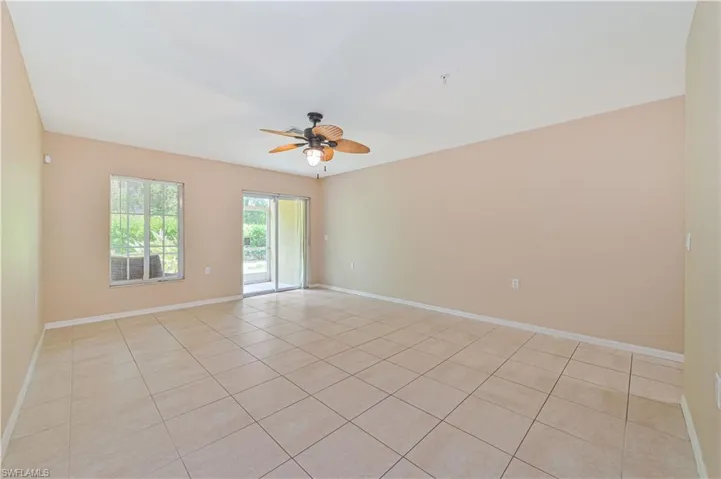 Empty room featuring ceiling fan and light tile floors