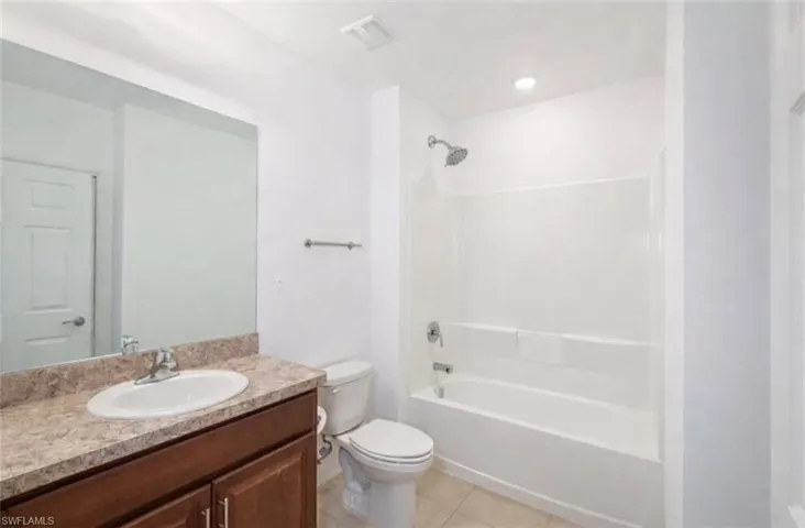 Full bath with vanity, shower / tub combination, and light tile patterned flooring