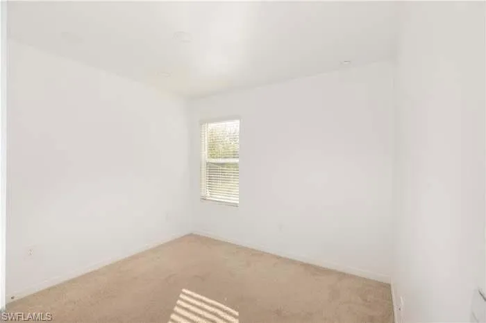 Empty room with carpet and baseboards
