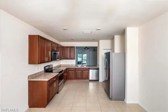 Kitchen featuring stainless steel appliances, light countertops, and light tile patterned floors