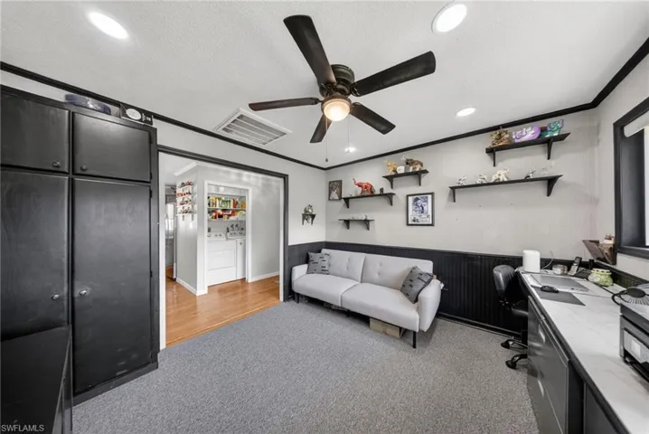 This room features carpeted flooring, a ceiling fan with integrated lighting, and recessed lighting