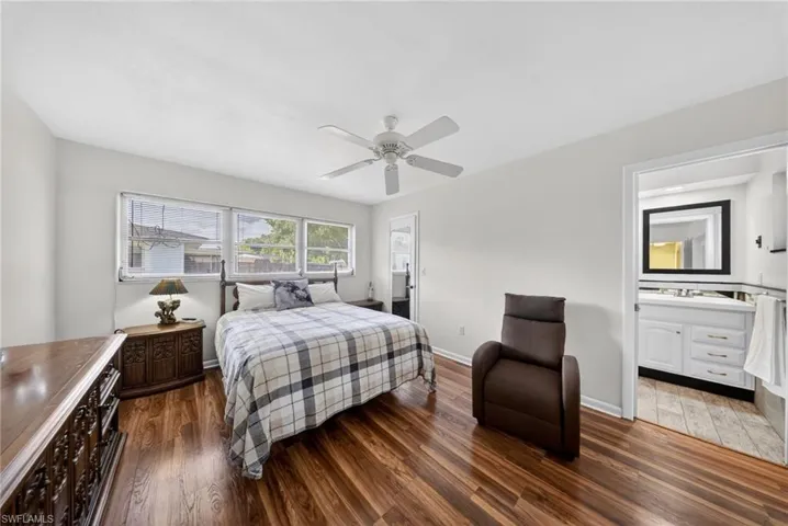 This room features wood-look flooring, light-colored walls, and a ceiling fan