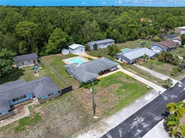 The property features a private swimming pool, a spacious yard, and a separate outbuilding