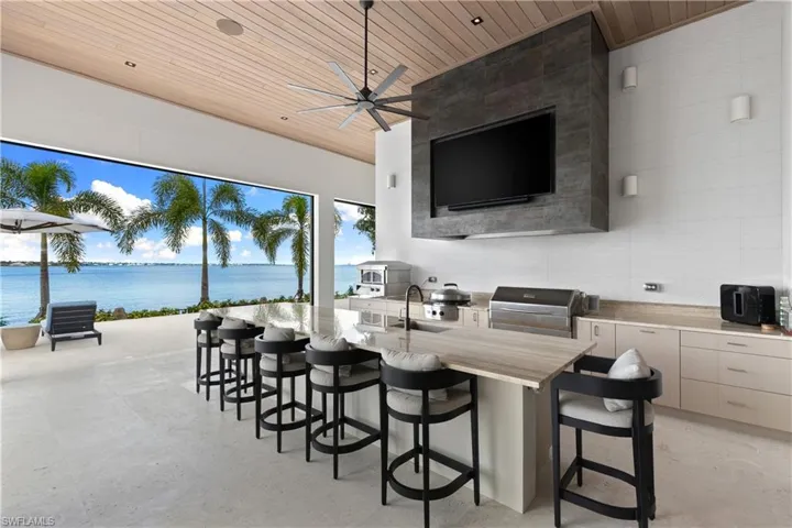 The outdoor space offers Memphis pellet grill, alfresco pizza oven, Evo flattop grill. Restaurant quality hood. Icemaker, 2 refrigerator drawers. Composite tongue and grove ceiling. Travertine countertops.