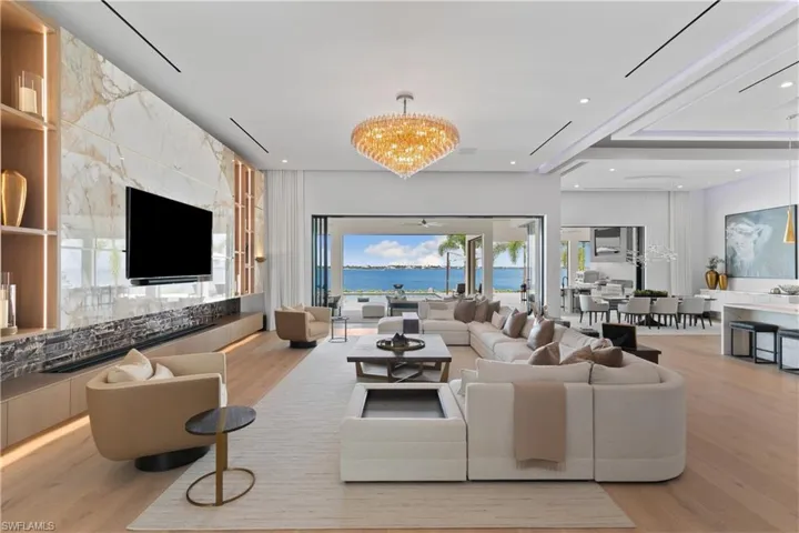 Great room adorned with hand-selected Italian marble, 12-foot water vapor fireplace, and a gorgeous hand-blown light fixture from Restoration Hardware.