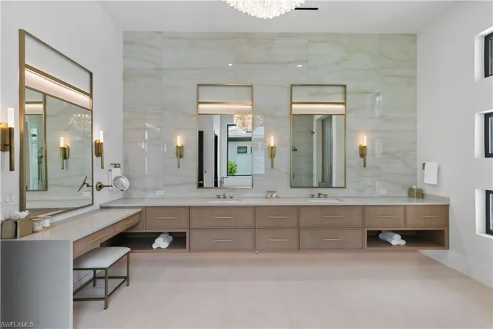 An opulent spa-like primary bath has quartz countertops, porcelain countertop to ceilings. Dual vanities, dressing area. Custom backlit mirrors. All Brizo plumbing fixtures throughtout the home. Toto "neorest" toilets.