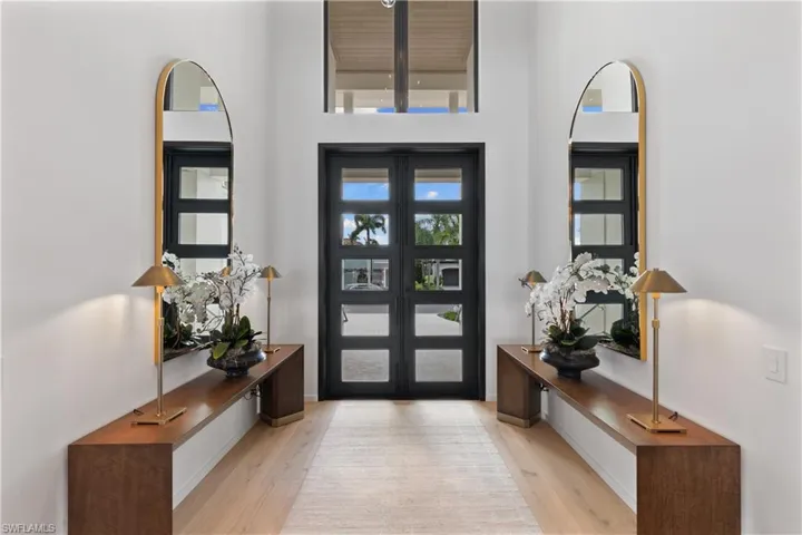From the moment you cross the threshold boasting 10 ft. Suncoast wrought iron front doors, be enveloped by the warmth of the inviting White Oak wide-plank flooring throughout and the awe-inspiring views!