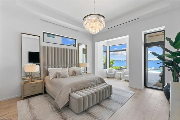 Primary suite offers a seating area views of the river, transom windows, and access to the lanai.