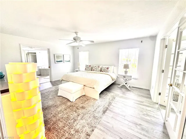 Bedroom featuring multiple windows, wood finished floors, and a ceiling fan