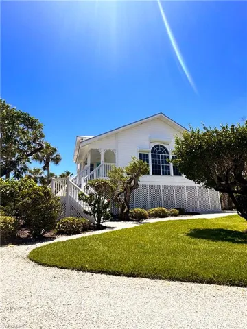 View of front of house featuring a front lawn and stairs