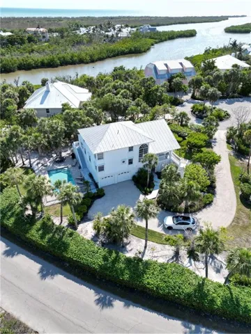 Drone / aerial view of a nearby body of water and a pool