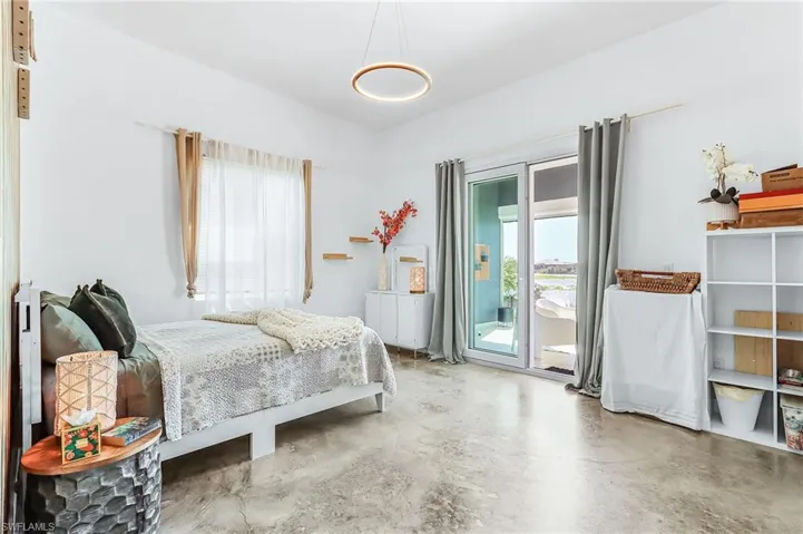 Bedroom featuring concrete flooring and access to outside