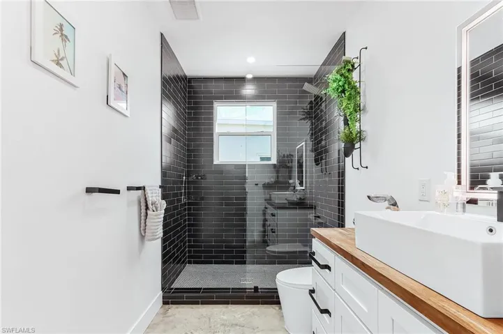 Full bath featuring vanity, a tile shower, and recessed lighting
