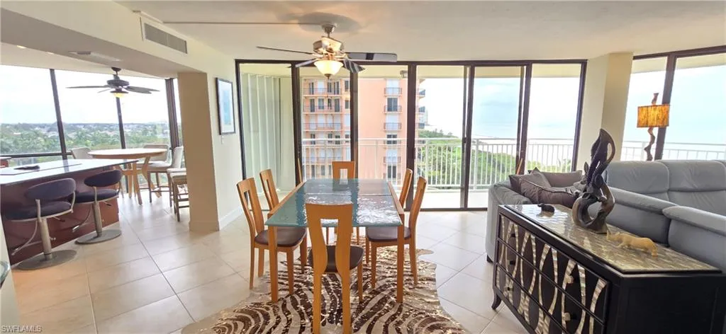 Dining room featuring ceiling fan, light tile patterned floors, and a healthy amount of sunlight