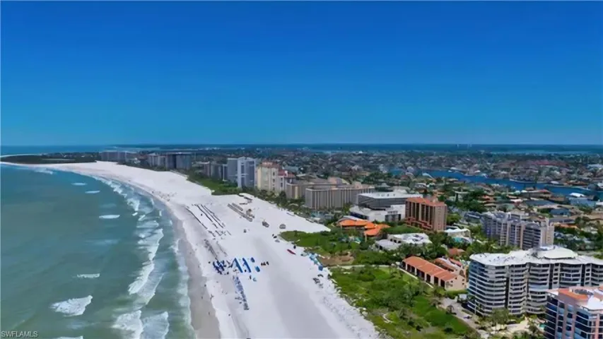 Birds eye view of property featuring a water view and a beach view