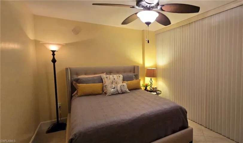 Bedroom with light tile patterned flooring and ceiling fan