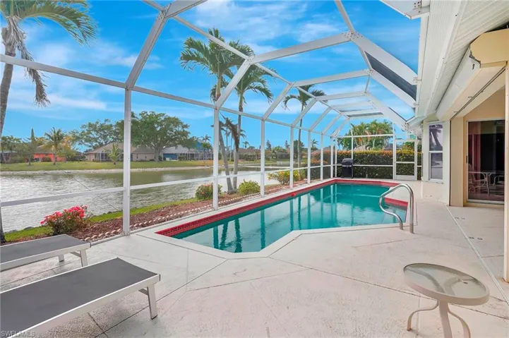 Pool with a patio, a water view, and glass enclosure