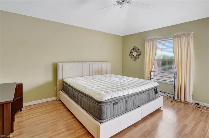 Bedroom featuring baseboards, a ceiling fan, and light wood-type flooring