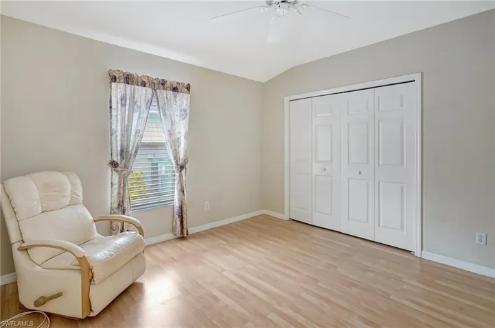 Sitting room featuring baseboards, lofted ceiling, ceiling fan, and light wood finished floors