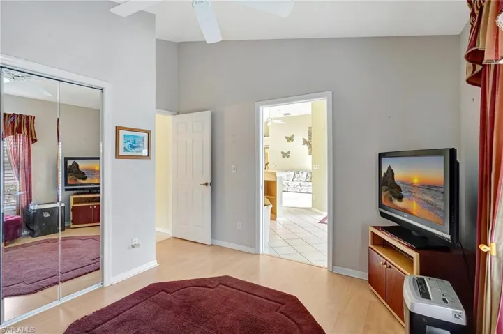Bedroom with a closet, lofted ceiling, baseboards, and light wood-type flooring
