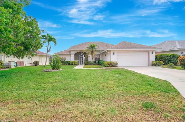 Ranch-style home with stucco siding, a garage, concrete driveway, and a front yard