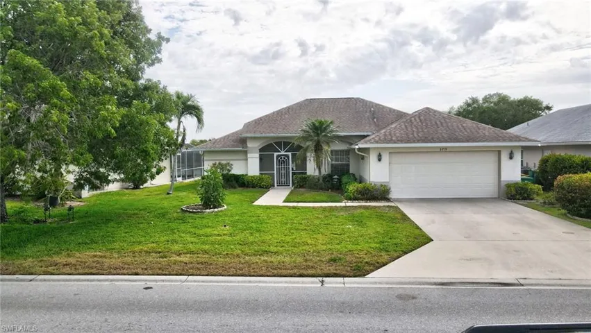 Single story home with a garage, stucco siding, a front yard, driveway, and a shingled roof
