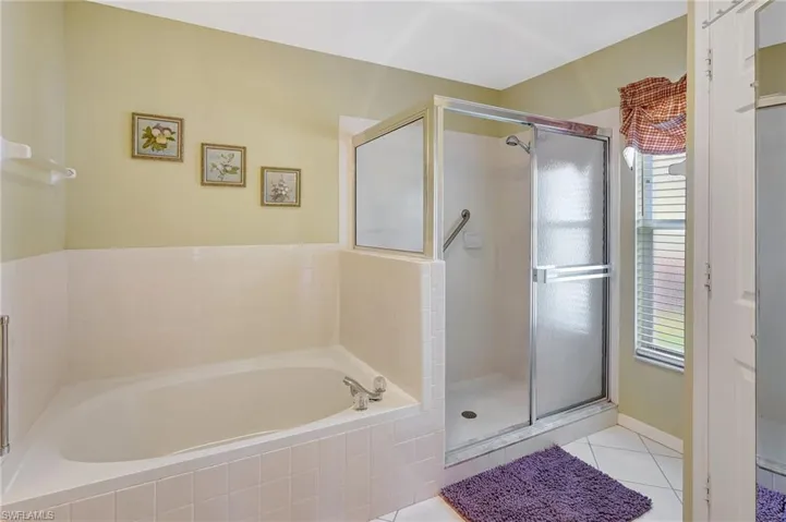 Bathroom with a stall shower, tile patterned flooring, and a garden tub