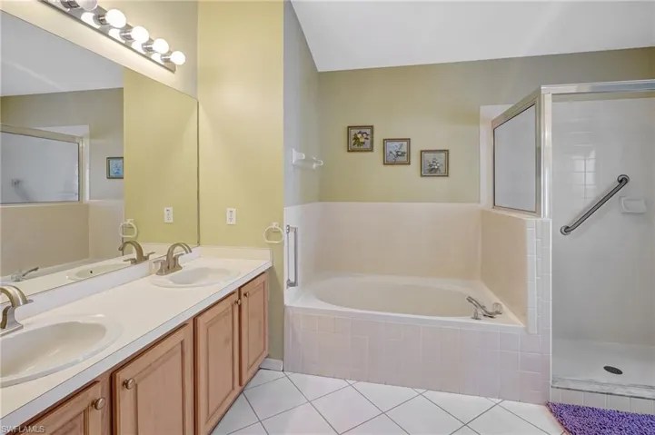 Full bath featuring tile patterned flooring, a sink, and a garden tub