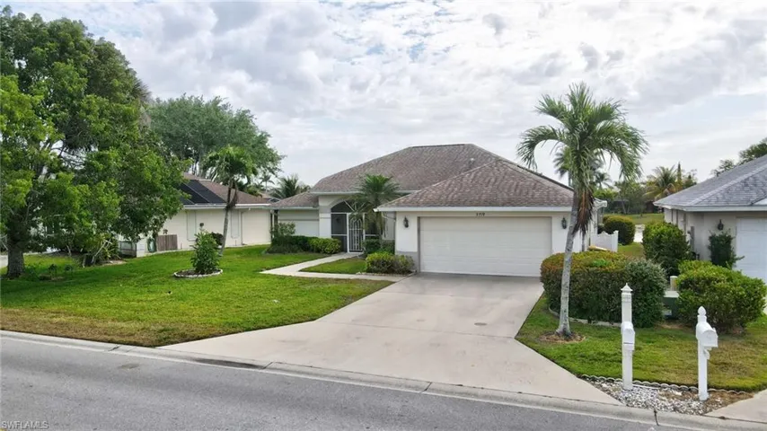 Ranch-style house with a garage, stucco siding, a front yard, roof with shingles, and driveway