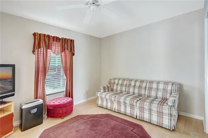 Living room with wood finished floors, baseboards, and ceiling fan