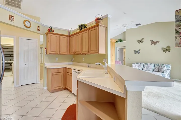 Kitchen featuring light tile patterned flooring, open shelves, a peninsula, visible vents, and ceiling fan