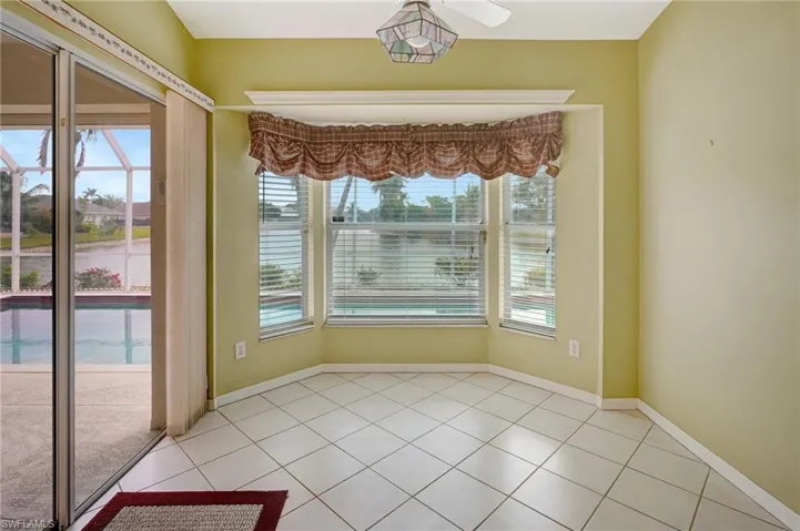 Unfurnished dining area with light tile patterned flooring and baseboards