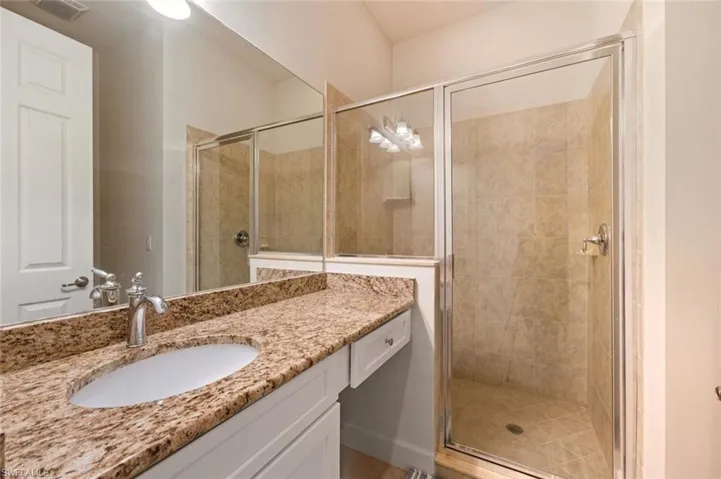Full bathroom with vanity and a shower stall