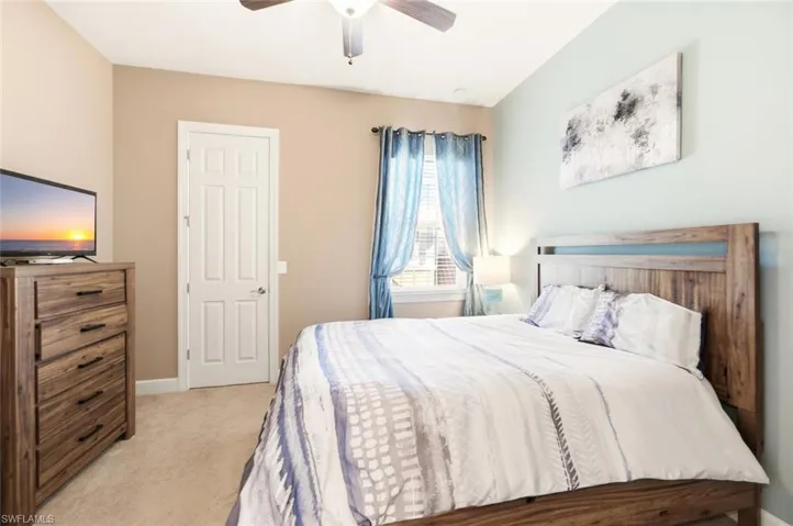 Bedroom with light carpet and a ceiling fan