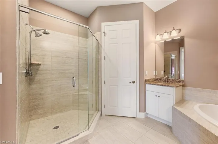 Full bathroom with vanity, a shower stall, a bath, and light tile patterned floors
