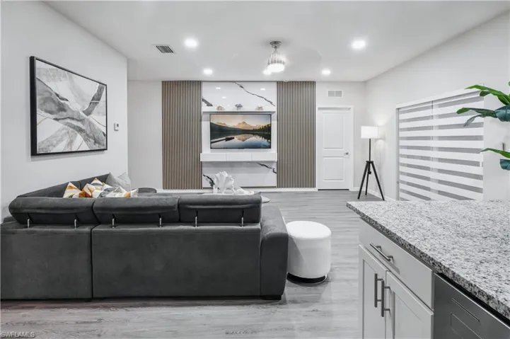 Living room with light wood finished floors and recessed lighting