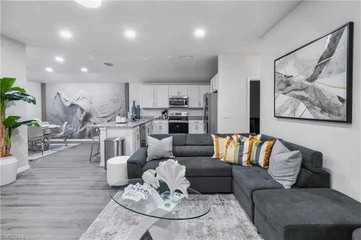 Living room with light wood finished floors and recessed lighting