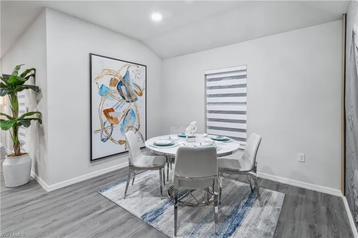 Dining space featuring vaulted ceiling and wood finished floors