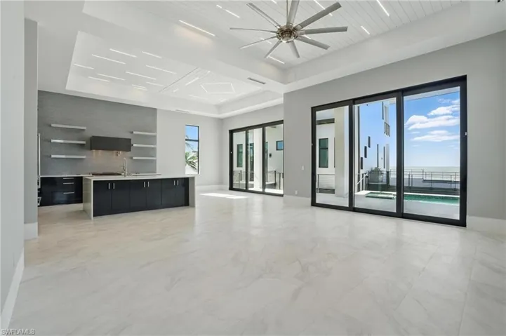 Unfurnished living room with ceiling fan and a wood tray ceilingVirtually Enhanced
