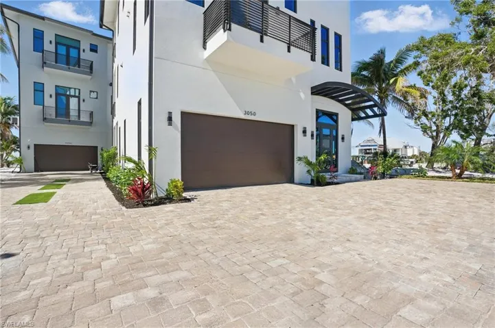 Contemporary house featuring stucco siding, an attached garage, and driveway Virtually Enhanced