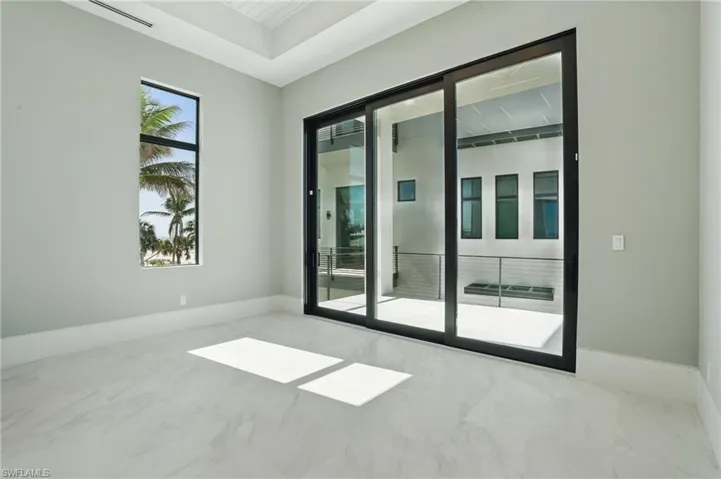 Empty room featuring baseboards and light marble finish flooring Virtually Enhanced