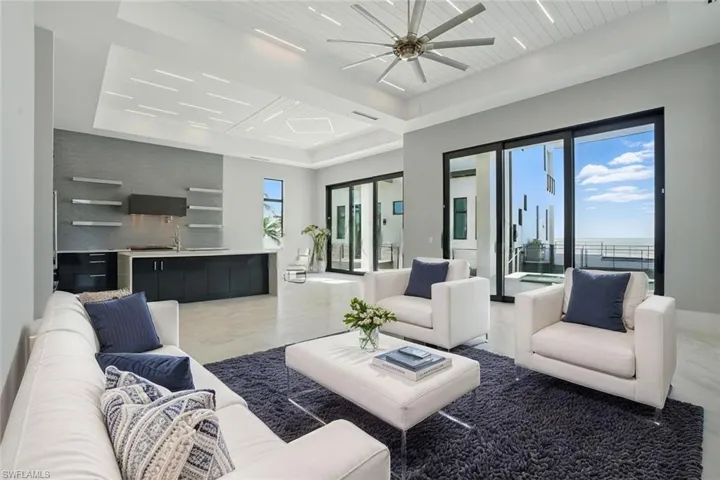 Living area with a ceiling fan and a wooden tray ceilingVirtually Enhanced