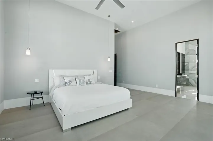 Bedroom featuring a high ceiling, a ceiling fan, and connected bathroom Virtually Enhanced