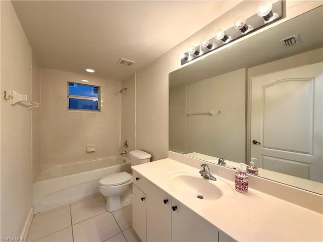 Full bath featuring shower / washtub combination, vanity, and light tile patterned flooring